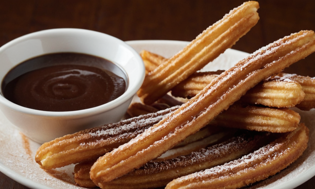 Una foto de churros crujientes y dorados con salsa picante de chocolate.
