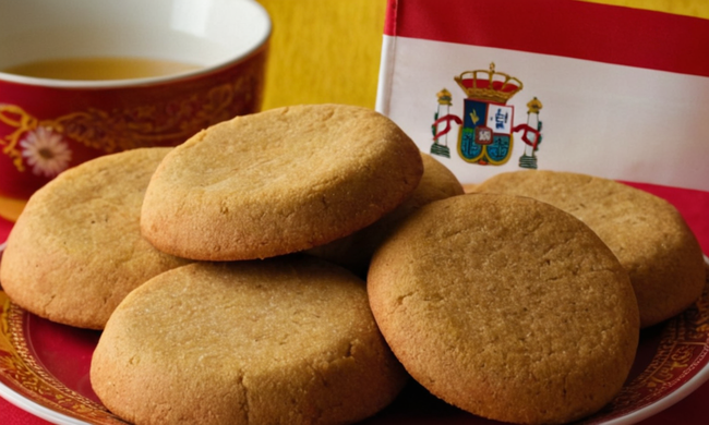 Un plato de polvorones tradicionales con banderas y símbolos culturales de países de habla hispana alrededor, destacando su popularidad.